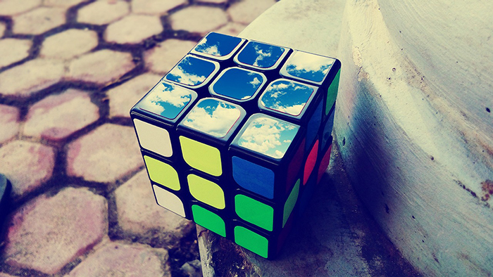 Rubikin kuutio, jonka päälle päin oleva sivu heijastaa taivasta.